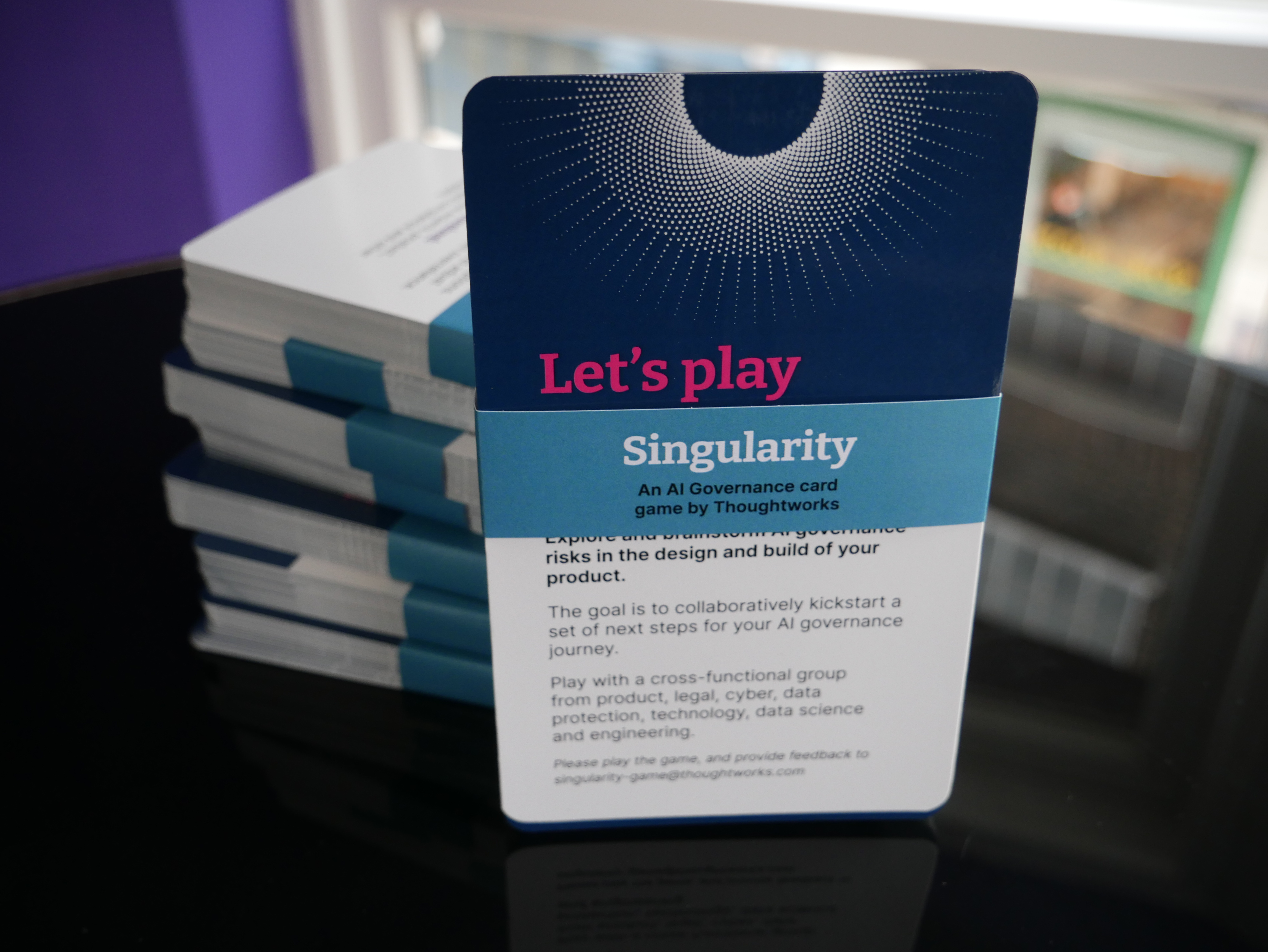 A card deck showing a title card that reads "Let's play Singularity: an AI governance game from Thoughtworks"